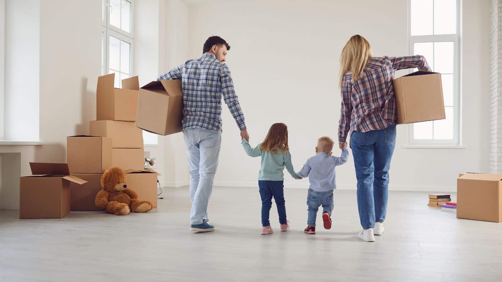 Family carrying moving boxes out of a home