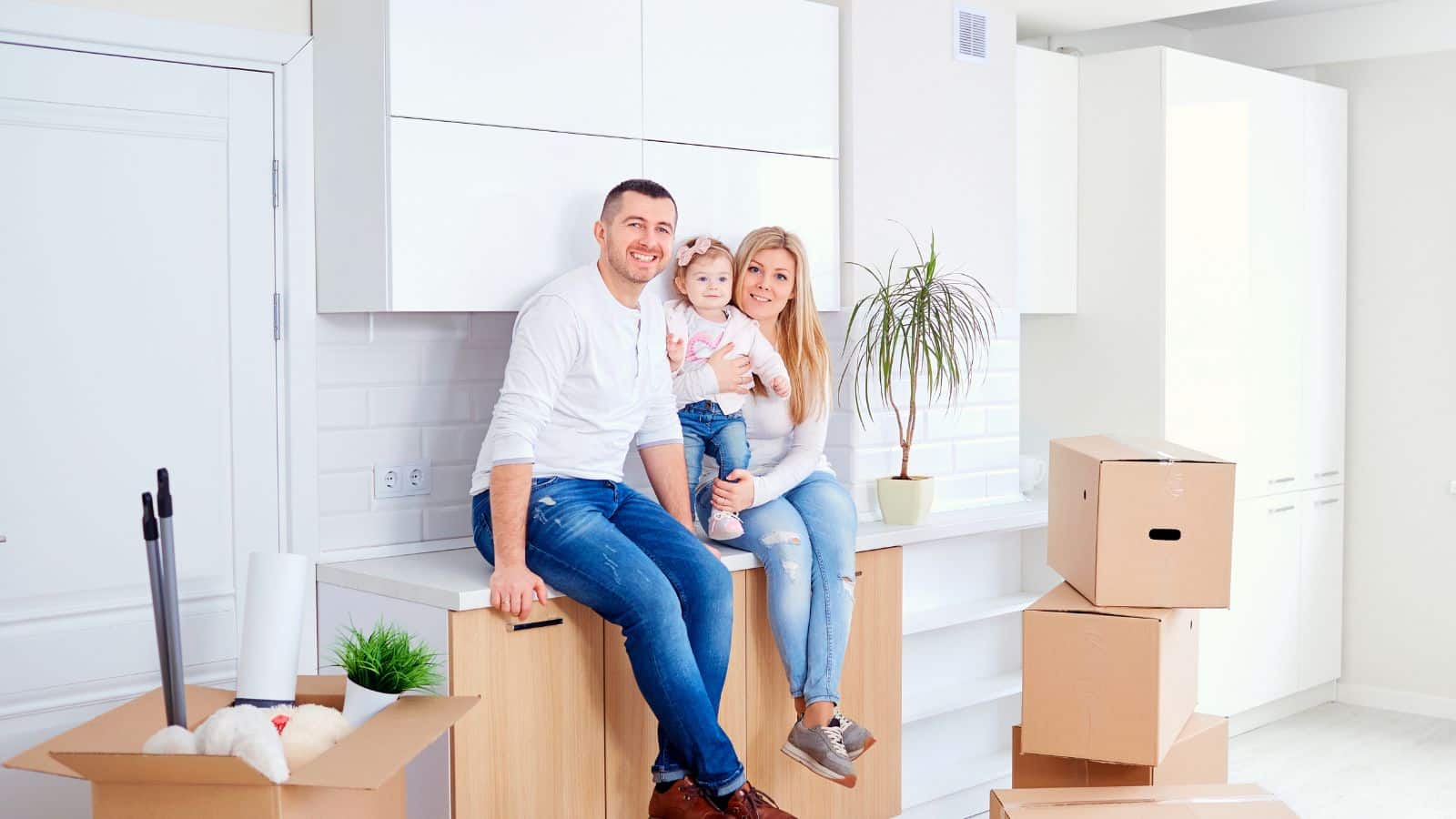 family sitting on top of moving boxes