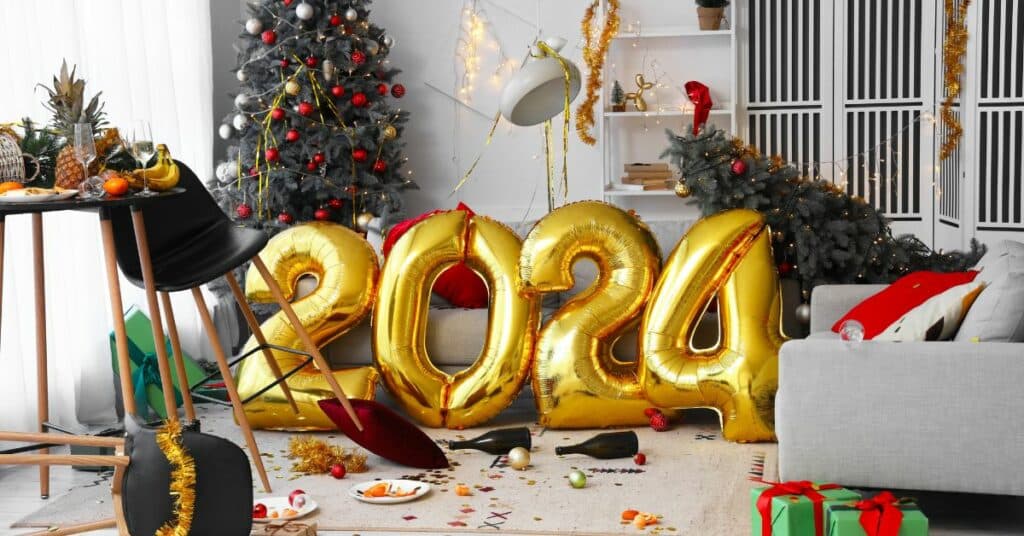 Messy living room with large gold balloons that say 2024