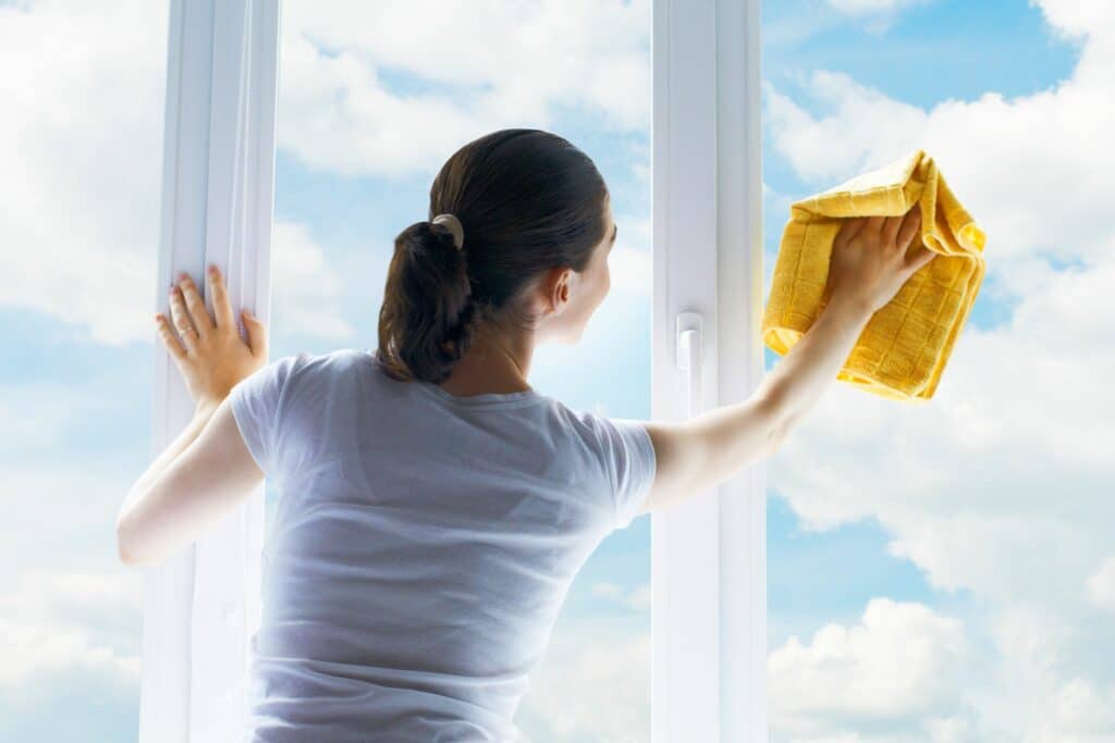 a woman cleaning a window but conducting the cleaning task wrong